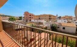 Balcony with metal railing and view of roofs and buildings in the central location of Cala Ratjada