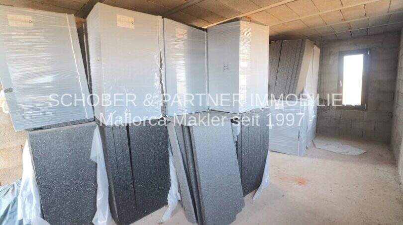 Rohbau mit gelagerten Granitplatten und verpackten Materialien für den weiteren Innenausbau des Landhauses in Port de Manacor