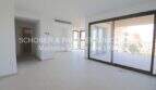 Helles Wohnzimmer mit großer Glasfront und Balkonzugang in modernem Neubau-Appartement in Cala Millor