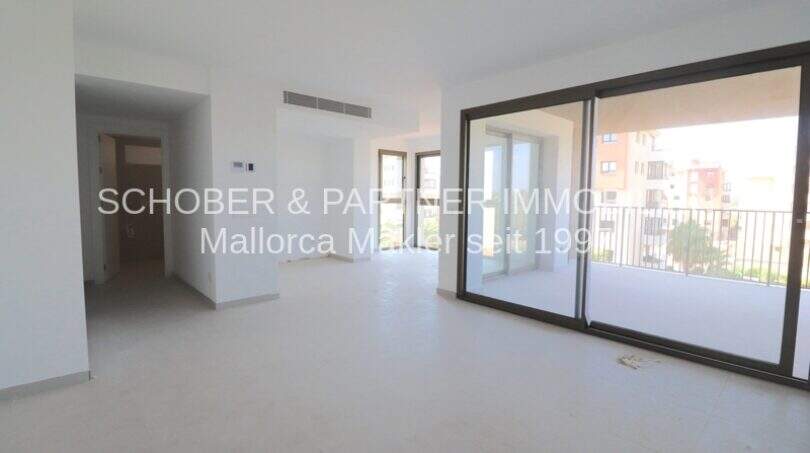 Helles Wohnzimmer mit großer Glasfront und Balkonzugang in modernem Neubau-Appartement in Cala Millor
