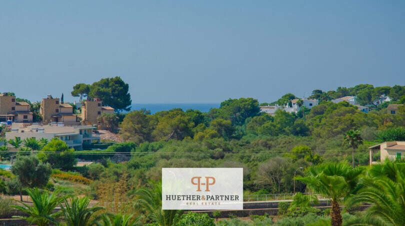 Panoramablick auf Porto Cristo Novo mit Meerblick, Pinien und mediterranen Villen im Grünen.