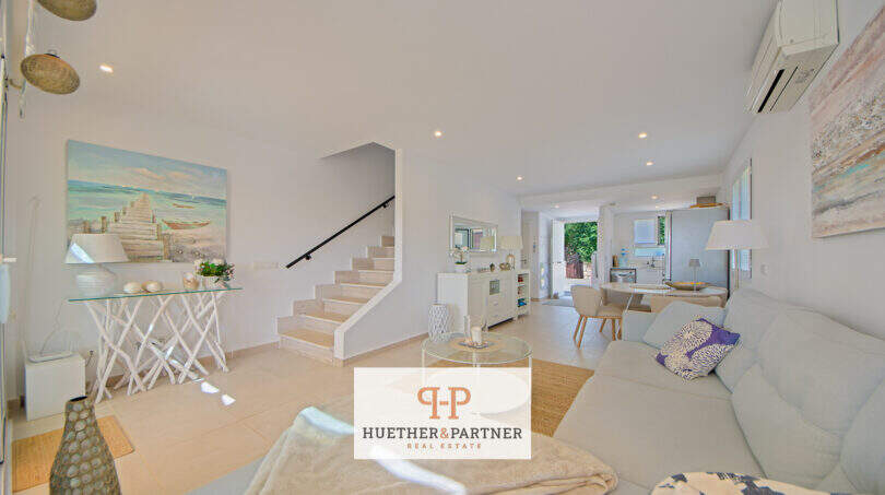 Helles Wohnzimmer mit Treppe, Sofa und Meeresdeko im Reiheneckhaus Porto Cristo Novo
