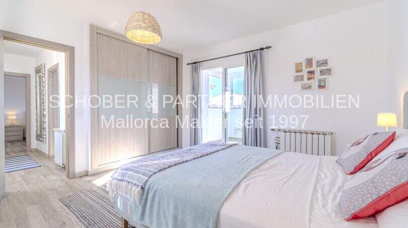 Helles Schlafzimmer der mediterranen Villa in Sa Coma mit Doppelbett, Einbauschrank und Balkonzugang.
