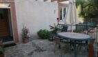 Sunny terrace with natural stone floor, garden furniture and umbrella at the chalet in Cala Murada