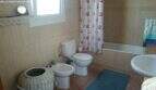 Tiled bathroom with bathtub, shower curtain, toilet, bidet and sink in the Cala Murada chalet