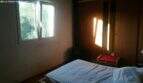 Bedroom of the Cala Murada chalet with double bed, built-in wardrobe and window with forest view.