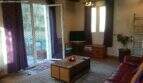 Living room of the chalet in Cala Murada with leather sofa, wooden furniture, purple curtains and terrace access to the forest.