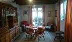 Bright dining room with round wooden table, chairs, rustic cabinet and terrace access with garden view in the Cala Murada chalet