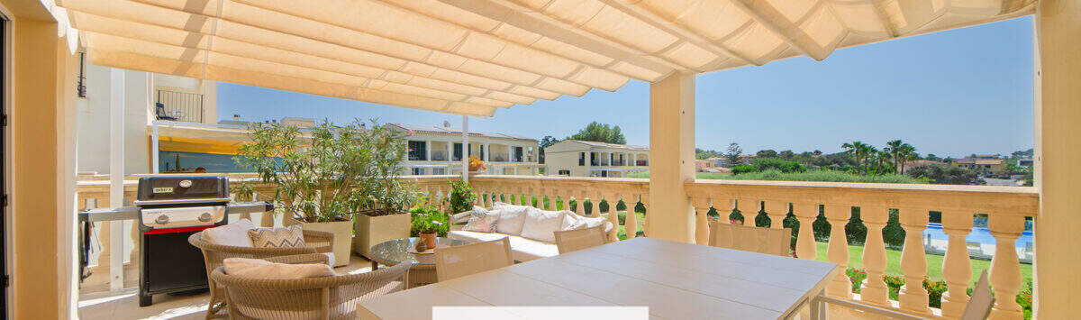 Sonnige Terrasse mit Markise, Essbereich, Lounge und Grillplatz, Blick auf Garten und Nachbarschaft in Porto Cristo Novo.
