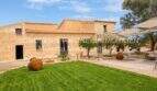 Saniertes Mallorca-Landhaus mit gepflegtem Rasen, Sandsteinfassade, Terrakotta-Amphoren und überdachter Terrasse