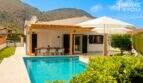 Bungalow Alcúdia: Terrasse mit Pergola, Esstisch und türkisblauem Salzwasserpool, Bergpanorama im Hintergrund