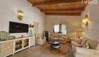 Wohnzimmer mit Holzbalkendecke, hellen Sofas, TV-Sideboard und mediterranem Dekor im Bungalow Alcúdia