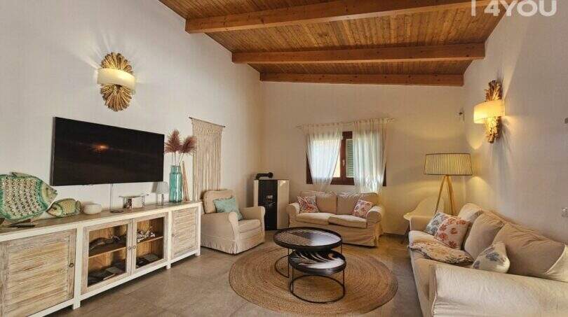 Wohnzimmer mit Holzbalkendecke, hellen Sofas, TV-Sideboard und mediterranem Dekor im Bungalow Alcúdia