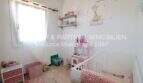 Habitación infantil con cuna, juguetes, decoración de pared con jirafa y ventana en apartamento Porto Cristo