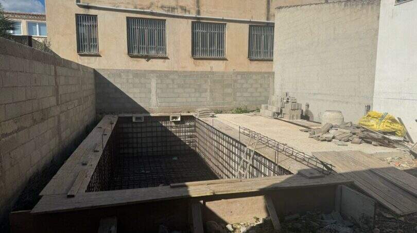 Pool im Rohbau mit Stahlarmierung und Betonwänden im Innenhof des Stadthauses in Sant Llorenç.