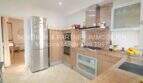 Modern fitted kitchen with wooden fronts, stainless steel refrigerator and granite countertop in Son Servera