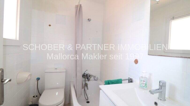 Helles Badezimmer mit Badewanne, Dusche, WC und Waschbecken in modernisierter Wohnung in Cala Ratjada