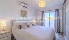 Elegantes Schlafzimmer der mediterranen Villa in Sa Coma mit Doppelbett, Klimaanlage und Balkonzugang.