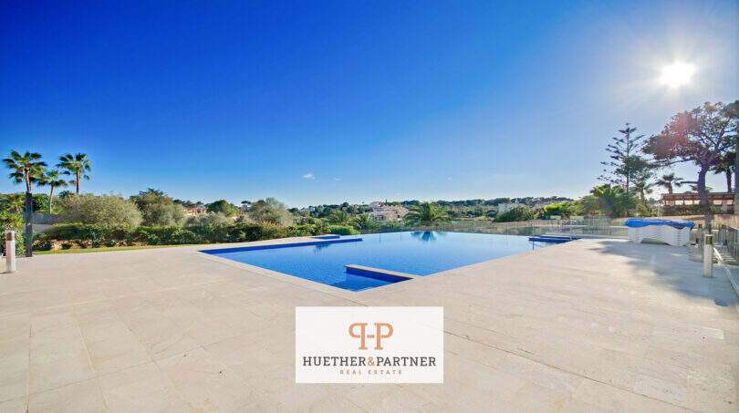 Großzügiger Infinity-Pool mit Natursteintetrasse und Grünblick beim Reiheneckhaus in Porto Cristo Novo.