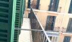 Balcón con contraventanas verdes y vistas a la fachada de edificio antiguo mediterráneo en el casco antiguo histórico de Palma