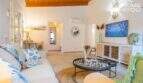 Helles Wohnzimmer mit weißem Sofa, Holzdecke, Flat-TV und mediterranem Dekor im Bungalow Alcúdia