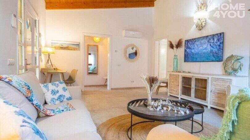 Helles Wohnzimmer mit weißem Sofa, Holzdecke, Flat-TV und mediterranem Dekor im Bungalow Alcúdia