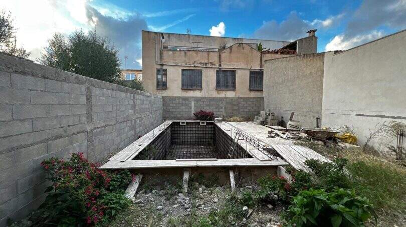 Rohbau eines Pools im Innenhof des Stadthauses in Sant Llorenç des Cardassar, umgeben von Mauern.