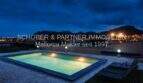 Illuminated pool at night with panoramic view of Son Servera and surrounding mountains