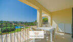 Sonnige Terrasse des Reiheneckhauses in Porto Cristo Novo mit Gartenmöbeln und Blick auf Pool und Grünanlage.