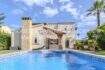 Mediterrane Villa in Sa Coma mit großem Swimmingpool, Steinverkleidung und Palmen im gepflegten Garten.