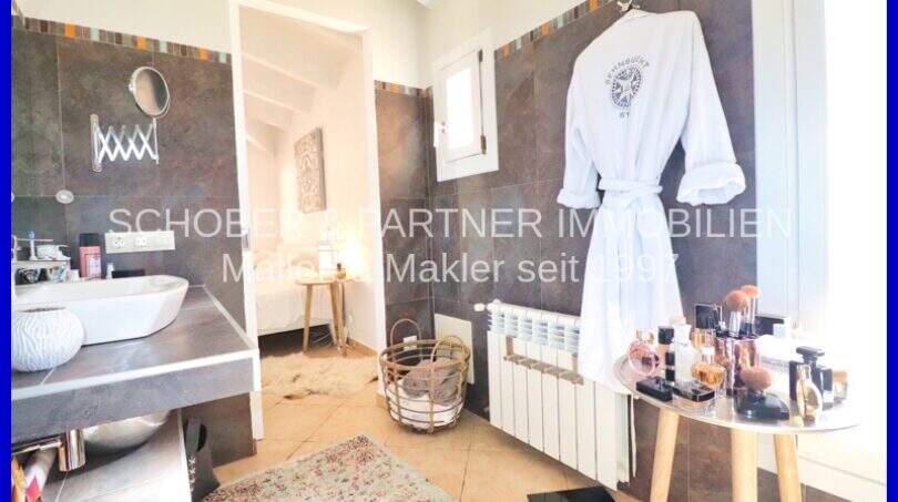 Elegant bathroom with dark tiles, sink, bathrobe and vanity in Villa Son Servera