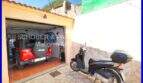 Garage with red Jeep and motor scooter in front of Mediterranean stone house in Son Servera, Mallorca