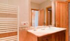 Badezimmer der Finca mit Marmor-Waschtisch, Holzschränken, großem Spiegel und Heizkörper in Felanitx