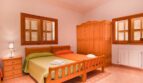 Helles Schlafzimmer der Finca mit Doppelbett, Holzmöbeln, Einbauschrank und Fensterläden in Felanitx.