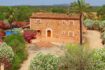 Finca aus Naturstein in Felanitx mit Pool, Palmen und blühenden Büschen in ruhiger Naturlage.