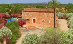 Finca aus Naturstein in Felanitx mit Pool, Palmen und blühenden Büschen in ruhiger Naturlage.