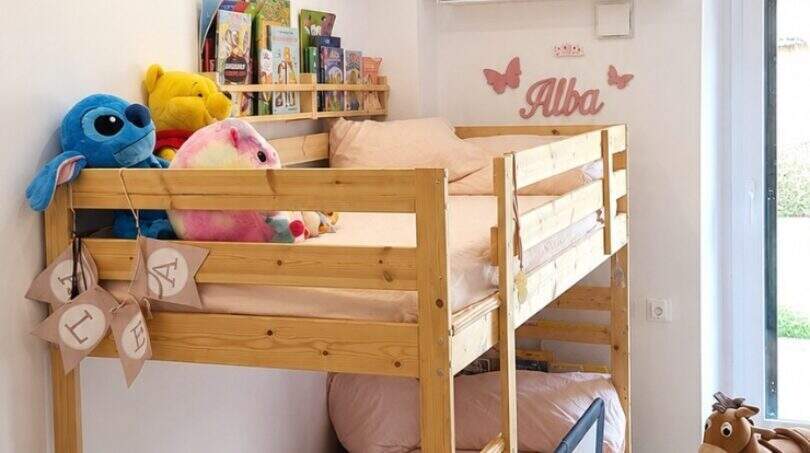 Kinderzimmer mit Etagenbett aus Holz, buntem Spielteppich und Spielzeug in einer Erdgeschosswohnung in Santa Maria del Camí.