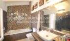 Modern bathroom with bathtub, mosaic tiles, sink and mirror in Villa Son Servera