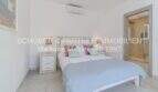 Helles Schlafzimmer der mediterranen Villa in Sa Coma mit Doppelbett, Klimaanlage und angrenzendem Bad.