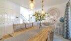 Elegantes Esszimmer der mediterranen Villa in Sa Coma mit Holztisch, Korbstühlen und stilvoller Pendelleuchte.