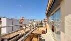 Sonnige Dachterrasse der Wohnung in Palma Blanquerna mit Stadtblick, Sitzbereich und Zugang zum Wohnbereich.
