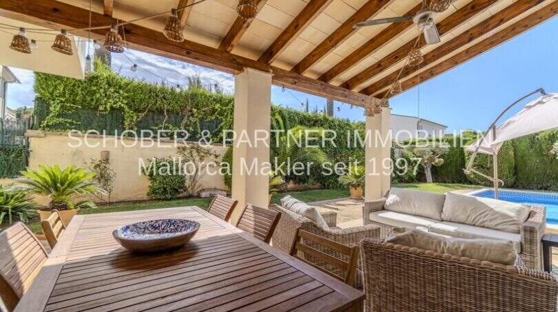 Überdachte Terrasse mit Holzbalken, Esstisch, Loungebereich und Pool in mediterraner Villa, Sa Coma