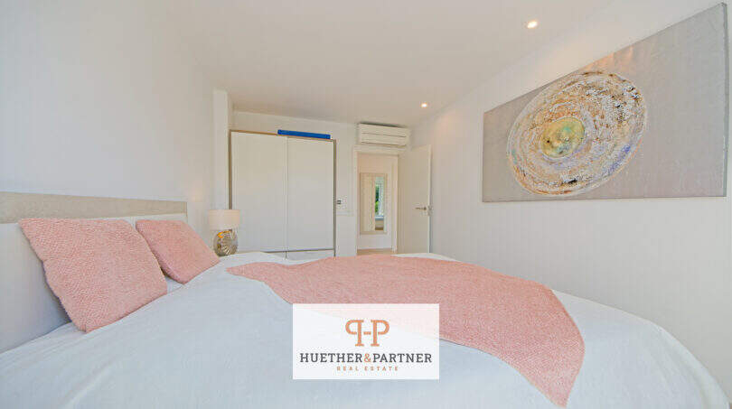 Helles Schlafzimmer im Reiheneckhaus Porto Cristo Novo mit rosa Akzenten, Einbauschrank und moderner Klimaanlage.