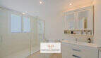Helles Badezimmer im Reiheneckhaus Porto Cristo Novo mit Glasdusche, WC und modernem Waschtisch.