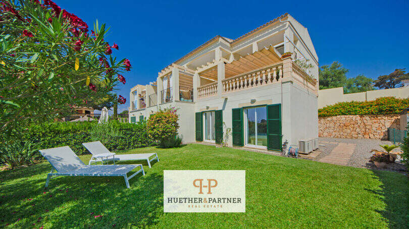 Reiheneckhaus Porto Cristo Novo: Gepflegter Garten mit Liegestühlen, weißer Fassade, grünen Fensterläden und Dachterrasse.