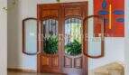 Eleganter Eingangsbereich mit Doppelholztür und Glasfenstern im mediterranen Einfamilienhaus in Sa Coma.