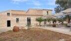 Außenansicht saniertes Landhaus Mallorca mit Natursteinmauern, Terrakottatöpfen und Sonnensegel im Innenhof