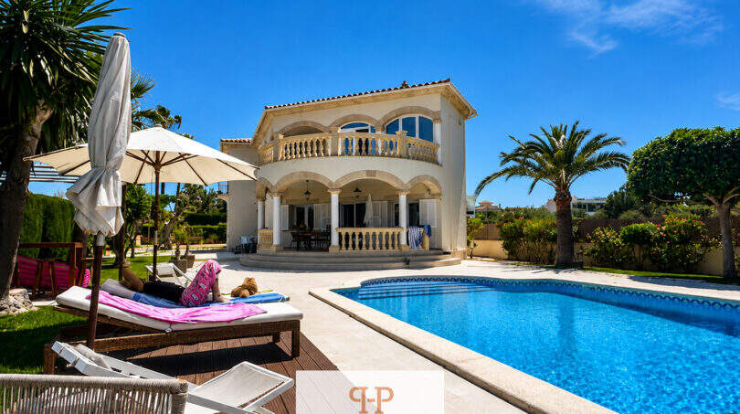 Villa Sa Torre Llucmajor: Mediterrane Außenansicht mit Pool, Sonnenterrasse, Palmen und Balkon unter blauem Himmel.