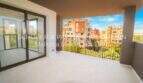 Spacious terrace with sliding glass door, view of apartment complex in Cala Millor, light tiled flooring, modern design