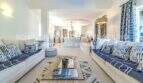 Geräumiges Wohnzimmer der mediterranen Villa mit blauen Sofas, Designerkissen und elegantem Tisch in Sa Coma